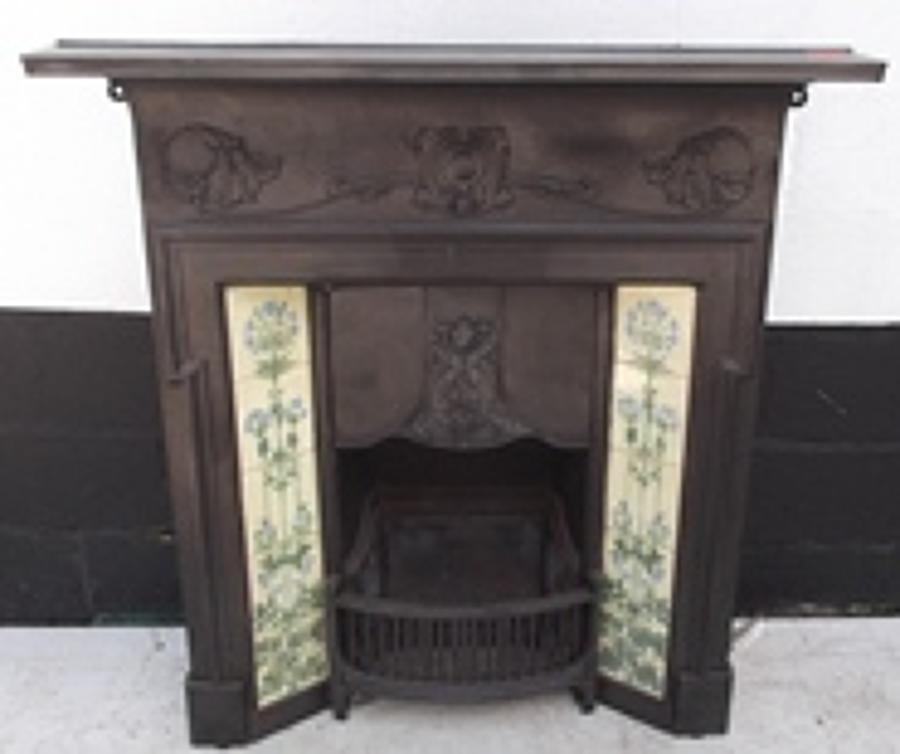 A decorative Art Nouveau cast iron tiled combination fireplace