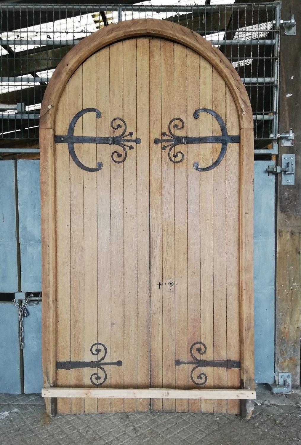 DP0257 A PAIR OF LARGE OAK AND PINE ARCHED GOTHIC DOORS AND FRAME