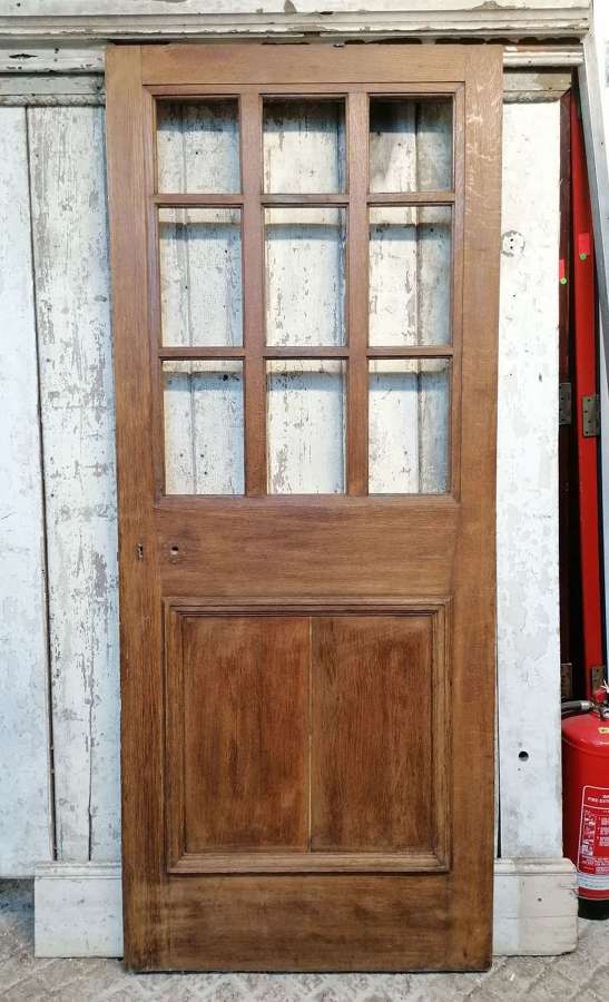 DE0922 A RECLAIMED EXTERNAL 1930's OAK DOOR WITH PANELS FOR GLAZING
