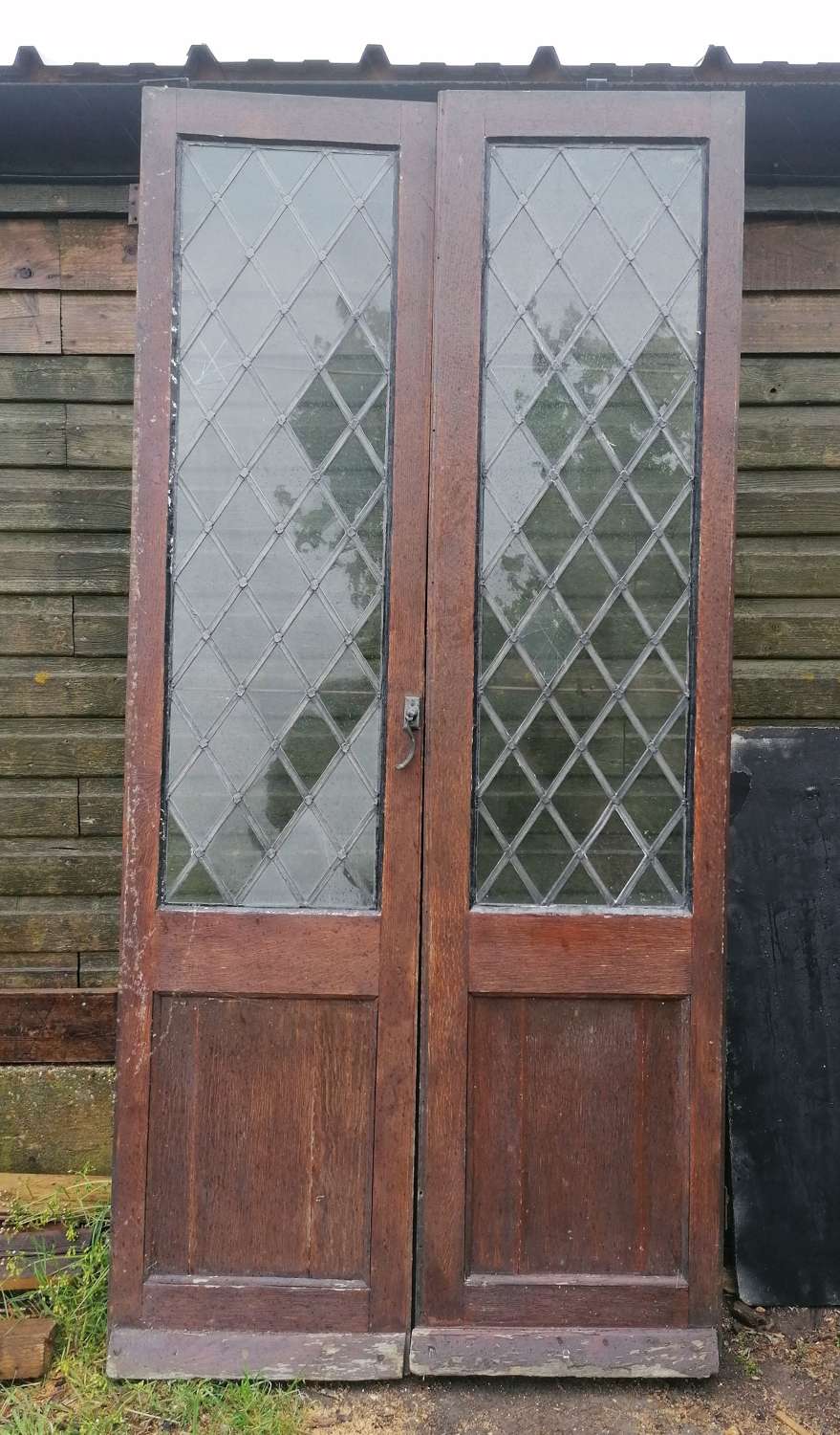 DP0397 A PAIR OF RECLAIMED OAK DOORS WITH LEADED GLASS